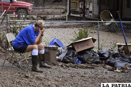 Teresa Reynolds se sienta exhausta mientras miembros de su comunidad despejan los escombros de casas destruidas por inundaciones 
/AP Foto/Timothy D. Easley