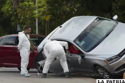 Médicos forenses trabajan el domingo en Apatzingán, México, en el sitio donde un hombre no identificado fue asesinado /AP Foto /Eduardo Verdugo