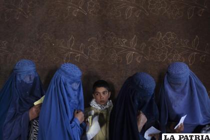 Mujeres afganas esperan para recibir dinero en efectivo en un punto de distribución de ayuda organizado por el Programa Mundial de Alimentos /AP Foto/Petros Giannakouris, archivo