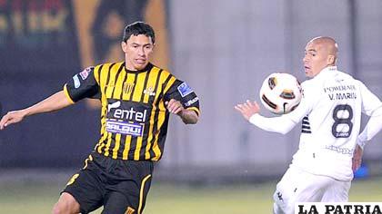 Enrique Parada (The Strongest) disputa el balón con Vladimir Marín (Olimpia)