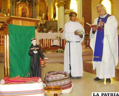El padre Jairo bendiciendo el pan y agua conmemorando la obra de San Felipe Benicio en el Santuario del Socavón