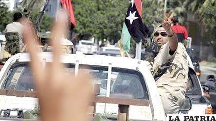 Unos soldados rebeldes libios escoltan a miembros del Consejo Nacional de Transición libio en Trípoli