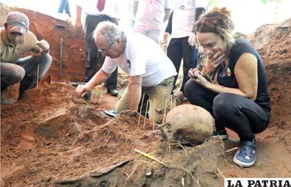Rogelio Goiburú descubre los restos que serían de su padre, Agustín Goiburú, mientras su hermana Patricia Goiburú observa con asombro