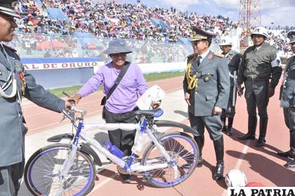 El general Ayllón entrega la bicicleta a la ganadora del sorteo