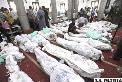 Varias personas permanecen junto a docenas de cadáveres de familiares en la mezquita al-Imene en El Cairo (Egipto)