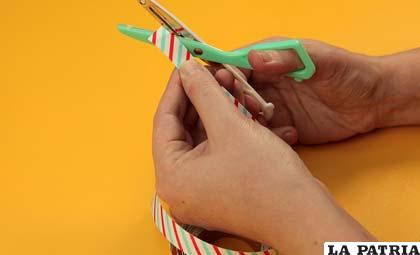 PASO 1
Comienza por cortar los bordes de la cinta adhesiva decorativa con la tijera para darles un borde más redondeado.