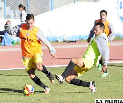 Gil Parada con el balón ante la marca de Arnaldo Vera