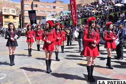 Las elegantes guaripoleras de la banda del Colegio San Miguel rinden honor a Bolivia