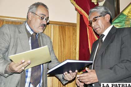 Luis Valdivia, secretario de Evaluación y Acreditación de Universidad Boliviana (izq.), entrega certificación a rector Augusto Vela