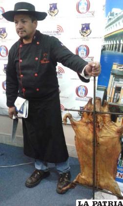 Jorge Antonio Monje junto al lechón a la cruz
