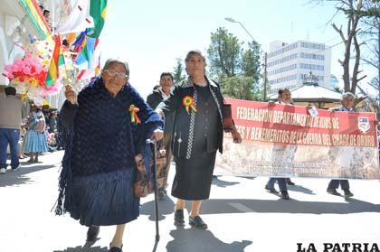Esposa de un ex combatiente de la Guerra del Chaco, orgullosa sostiene su bandera tricolor