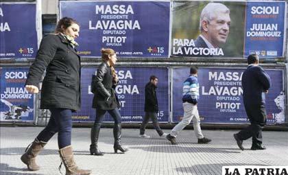 Transeúntes caminan frente a vallas con propaganda electoral en el centro de Buenos Aires /servidornoticias.com