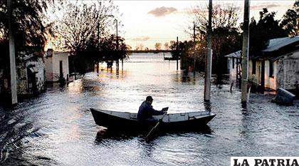 Un uruguayo atraviesa una calle en bote para llegar a su casa /diarioextra.com