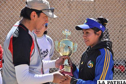 El dirigente Chungara entrega la copa de campeón a Rosario Padilla, del Club Cosmos