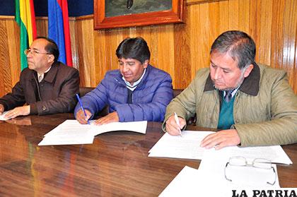 Carlos Antezana (der) rector de la UTO y Sandro Arias (centro)  gerente general de Amdeor, fueron los encargados de firmar el convenio