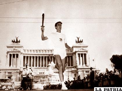 La antorcha olímpica llevada por un atleta pasa por la Plaza de Venecia en Roma durante los juegos de 1960 /ansabrasil.com.br