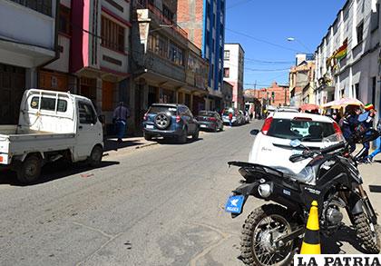 Vehículos ocupan ambos lados de la calzada y hasta parte de la acera en la calle Potosí