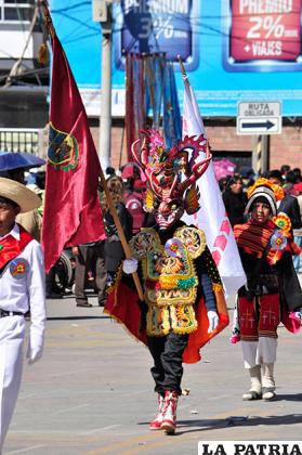 Traje representativo del Carnaval de Oruro portando el rojo carmesí en un estudiante de la unidad educativa Avelino Siñani