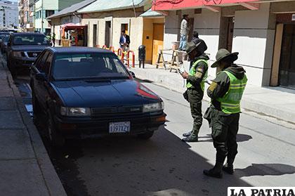 Efectivos de Tránsito colocando multas a los coches estacionados en la calle Sucre