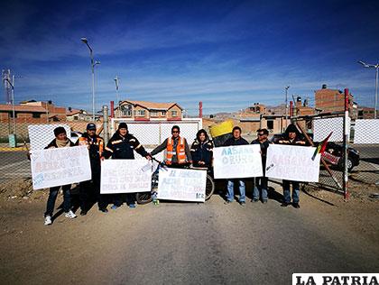 Los trabajadores de Aasana con carteles en mano protestan en puertas del Aeropuerto 