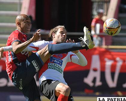 Alex Silva se anticipa a la marca ante la arremetida de Cristian Alessandrini /APG