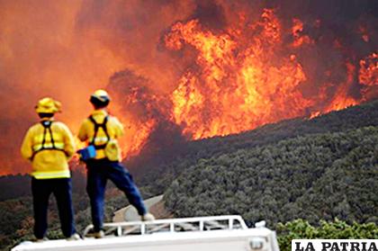 Bomberos observan la ladera de una colina en llamas en Lakeport, California /LATINXTODAY