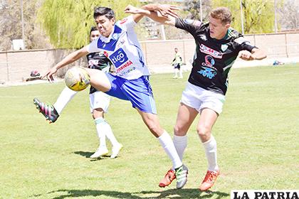 Hoyos intenta quitar el balón a su rival 
