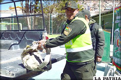 Un funcionario policial ayuda con una de las mochilas artesanales /LA PATRIA