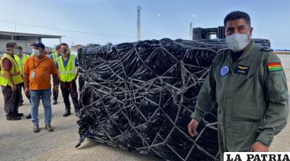 Un miembro del la FAB supervisa como se descarga un cargamento de alimentos y medicinas donados por Bolivia a Cuba /AFP