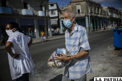 Leandro Rodríguez, de 69 años, lleva un paquete de alimentos donados por varios países después de recogerlo en una bodega estatal /AP Foto/Ramón Espinosa