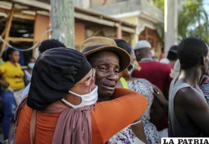 Dos personas se abrazan llorando mientras buscan desaparecidos entre los escombros de una casa destruida por un terremoto /AP Photo /Joseph Odelyn
