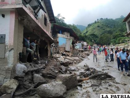 Personas caminan por una calle dañada por inundaciones y deslizamientos de tierra provocados por lluvias 
/Euro Lobo /Oficina estatal de prensa de Mérida via AP
