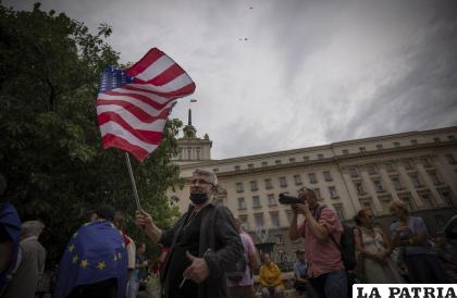 Un manifestante porta una bandera estadounidense durante una protesta contra la gigante gasera rusa Gazprom /AP Foto /Valentina Petrova