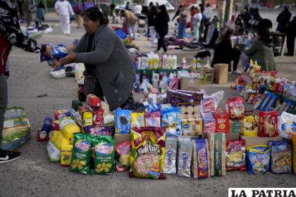 Una vendedora completa una transacción en un mercado donde la gente puede comprar o intercambiar bienes /AP Foto /Natacha Pisarenko