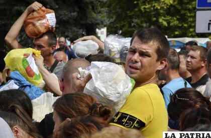 Residentes locales, muchos de los cuales huyeron de la guerra, se reúnen para entregar donativos como medicamentos, ropa y pertenencias a sus familiares /AP Foto /Andriy Andriyenko
