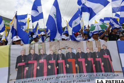 Manifestantes antigubernamentales sostienen una cita de Juan Pablo II que dice en español: “La primera que quiere la paz, es la Iglesia” /Foto AP/Alfredo Zúñiga, Archivo