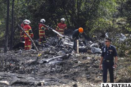 Oficiales del Departamento de Bomberos y Rescate de Malasia inspeccionan la escena del accidente /EFE