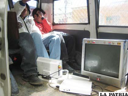 Los dos sujetos en un vehículo policial con los objetos que se robaron