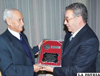El presidente de la directiva (derecha), Marco Gutiérrez otorgó el reconocimiento al galeno Javier Ruiz por su desempeño profesional