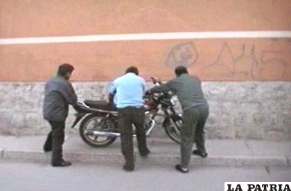 Ciudadanos levantan la motocicleta que se estrelló contra el pretil de la acera