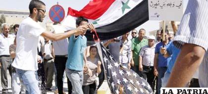 Un joven quema una bandera estadounidense en una protesta contra la posible intervención americana en Siria