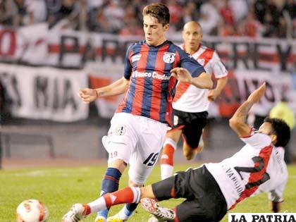 Leonel Vangioni, de River, intenta arrebatar el balón a Navarro, de San Lorenzo