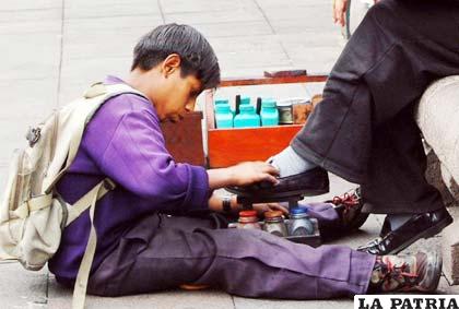 Un niño trabaja como lustra botas