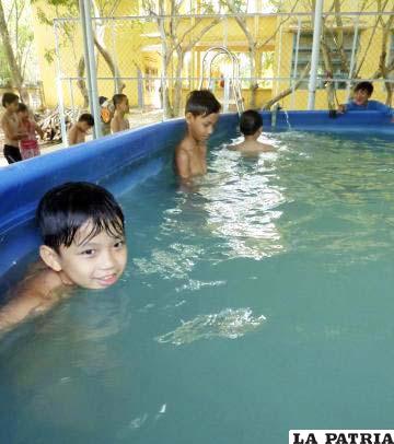 Varios niños, durante un curso de natación del programa SwimSafe (nadar con seguridad)