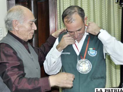 Julio Crispín entrega la medalla de campeón a Eduardo Baldivieso
