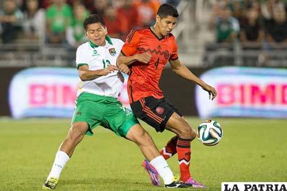 Carlos Saucedo y Hugo Ayala disputan el balón