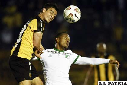 Diogo, de Peñarol, disputa el balón con Luis Mosquera, de Cali