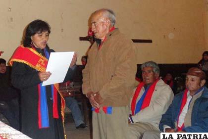 Nancy Chambi hace la entrega del la distinción a Armando Escóbar