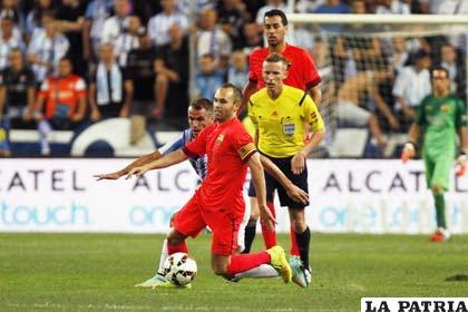 Iniesta intenta dominar la pelota ante la marca de su adversario