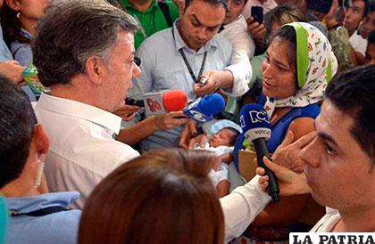 El presidente de Colombia, Juan Manuel Santos (izq.), habla con los expulsados de Venezuela /elnuevoherald.com